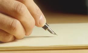 A close up photo of someone's hand about to write with fountain pen and paper