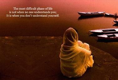 This is a photo of a woman in yellow sitting at the water's edge with her back to us looking out over small fishing boats.  The caption reads, "The most difficult phase of life is not when no one understands you, it is when you don't understand yourself."